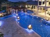 Luxury Pool With Fire PotsPhoto By: Joe TrainaThis home's water features put…